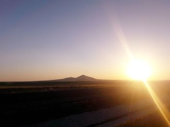 Scenic view of landscape against clear sky during sunset