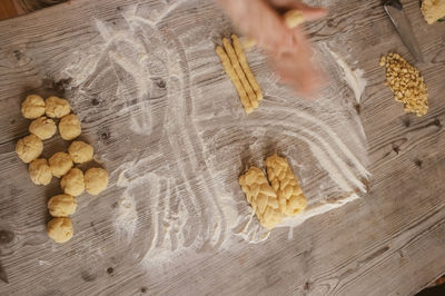 Cropped image of hand making breads on table