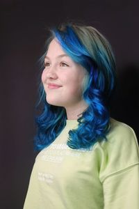 Portrait of young woman against black background