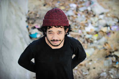 Portrait of young man wearing hat standing outdoors during winter