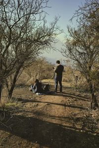 Man and dog on street against sky