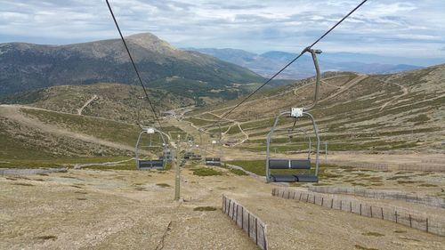 Overhead cable car in mountains against sky