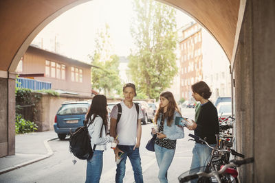 Teenagers talking while standing in tunnel