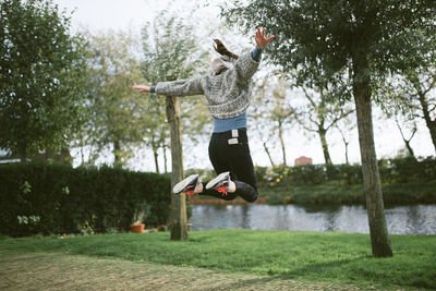 Full length of man jumping in mid-air against trees