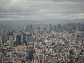 Aerial view of buildings in city against sky