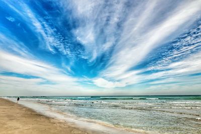 Scenic view of beach against cloudy sky