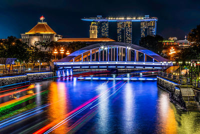 Light trails on bridge over river at night