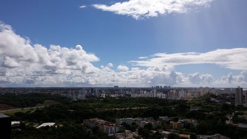 View of cityscape against cloudy sky
