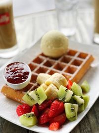 Close-up of fruits slices with waffle in plate