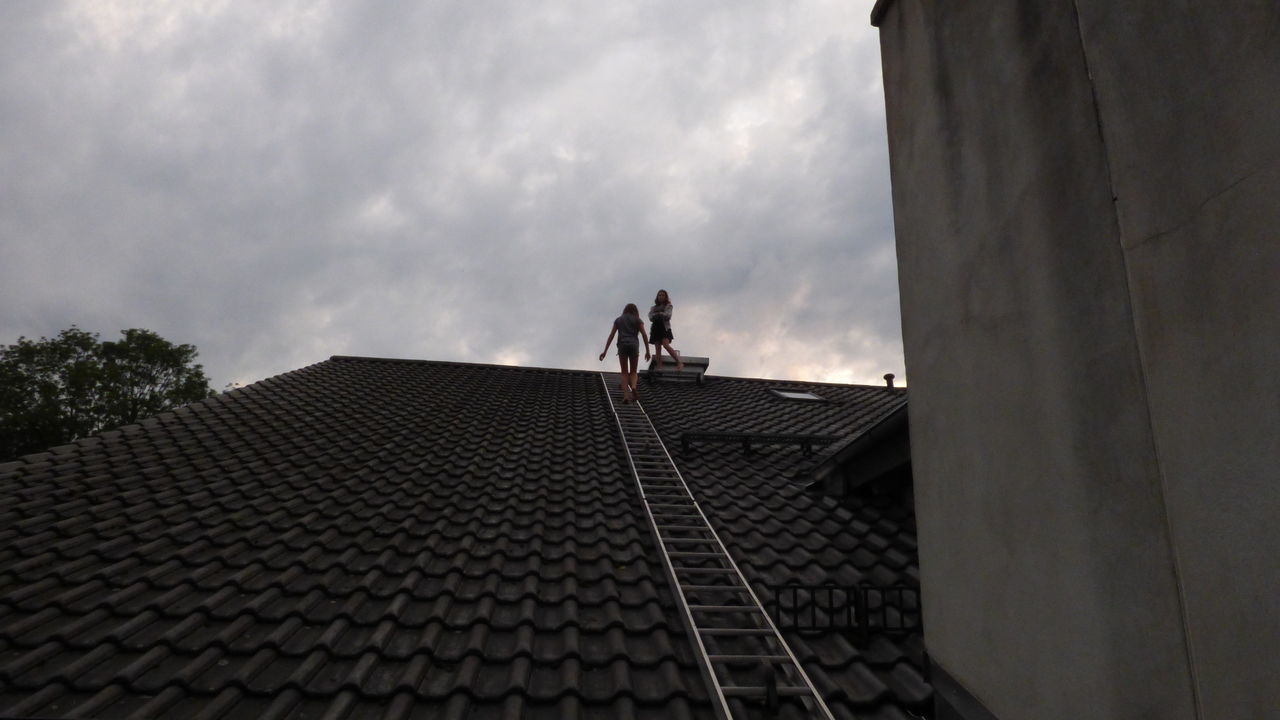 LOW ANGLE VIEW OF PEOPLE ON ROOF
