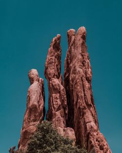 Low angle view of rock formation against clear blue sky