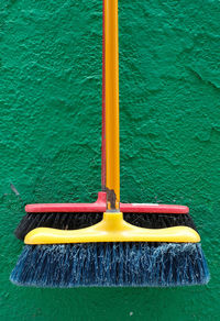 Colorful brooms hang on the colorful house wall, burano, a small island near venice, italy