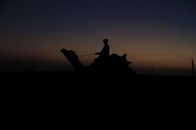 Silhouette men standing against clear sky during sunset