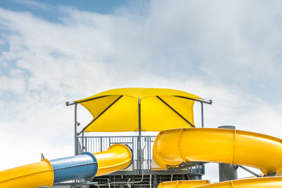 Low angle view of yellow flag against sky