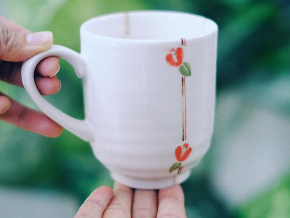 CLOSE-UP OF WOMAN HOLDING CUP OF TEA