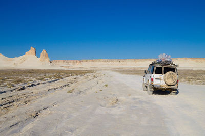 Scenic view of desert against clear blue sky