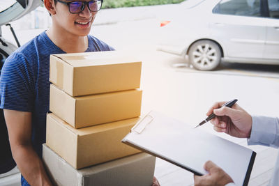 Man looking at male while signing on document