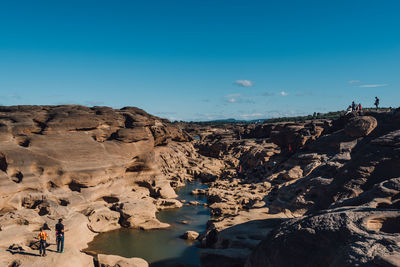 Scenic view of rock formations against blue sky