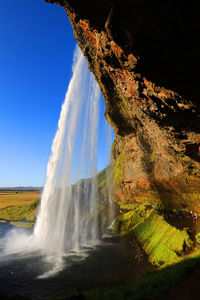 Scenic view of waterfall against sky