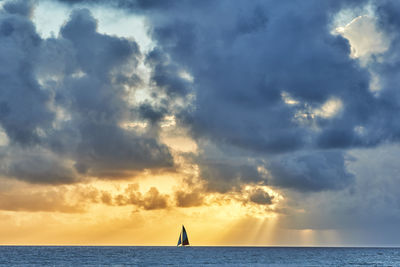 Sailboat sailing on sea against sky during sunset