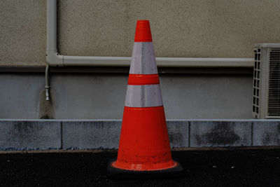 Red umbrella on road against wall in city