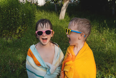 Wet cheerful children in sunglasses in a towel. summer is a time of pleasure and fun