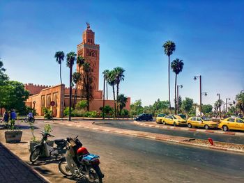 Cars on road in city against sky