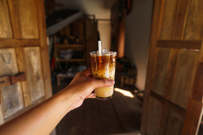 Cropped hand of woman holding cold coffee