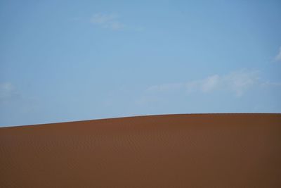 Sand dunes against blue sky