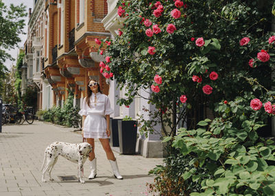 Low angle view of woman with dog standing by plants