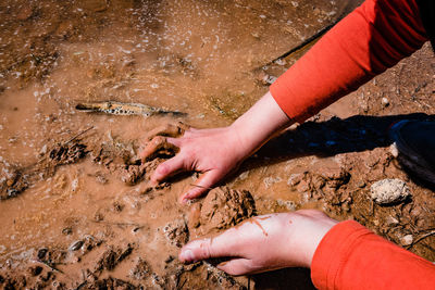 High angle view of hands touching water