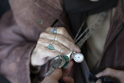 Midsection of senior woman showing pocket watch