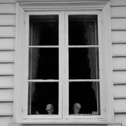 Portrait of man seen through glass window of building