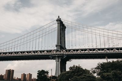 Low angle view of manhattan bridge against sky in city