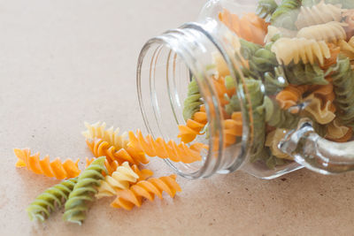 Close-up of pasta spilling from jar on table