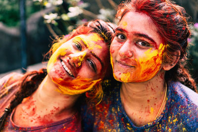 Portrait of smiling friends covered with powder paint