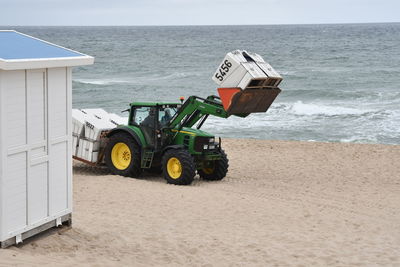 Deck chairs on beach against sky