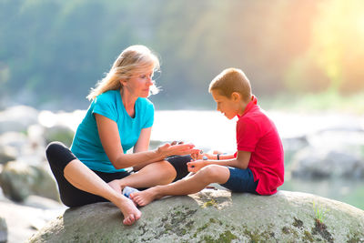 Boy sitting on rock