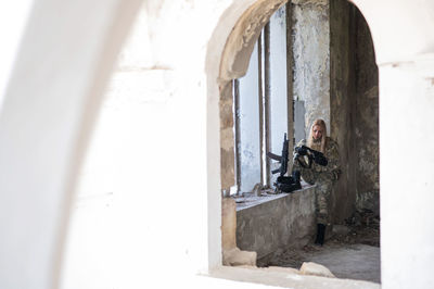 Rear view of woman standing against wall