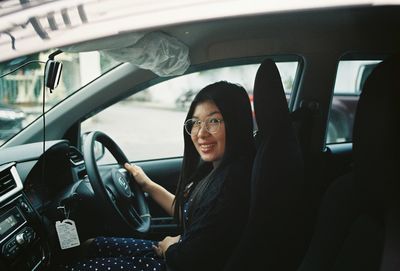 Portrait of smiling woman sitting in car