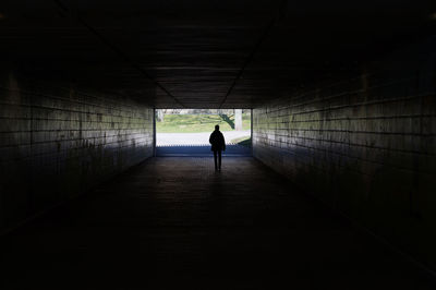 Rear view of man standing in tunnel