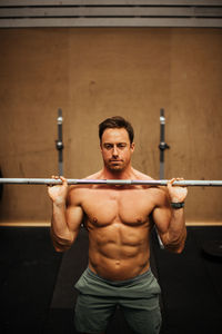 Shirtless man exercising in gym