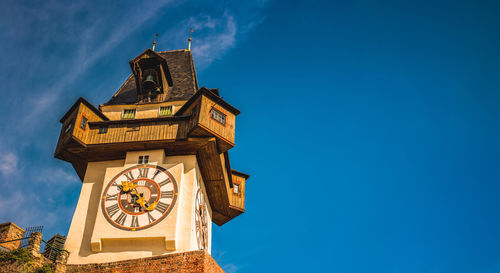  uhrturm landmark in graz cityscape view, styria region of austria. clocktower against blue sky
