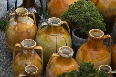 Close-up of earthen pots and potted plants on footpath