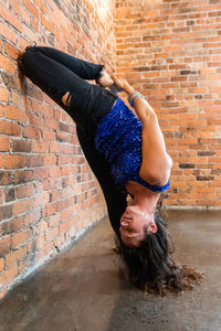 Full length portrait of woman against wall