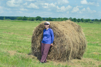 Full length of hay bales on field against sky