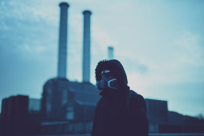 Portrait of man with mask standing against sky during sunset after coronavirus outbrake in berlin 