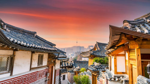 Buildings in city against sky during sunset