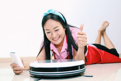 Portrait of smiling young woman using smart phone