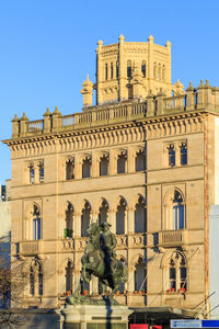 Statue of historic building against blue sky